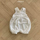 Ein beigefarbener, ärmelloser Baby-Strampler mit überkreuzten Trägern liegt flach auf einem Parkettboden. Oben im Bild ist das Wort „BEBEHOLIC“ zu sehen. Dieser Bebe Holic Leinen-Strampler mit Raffung verfügt über elastische Beinöffnungen für optimalen Komfort für Kleinkinder.