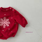 Ein roter Kleinkinderpullover mit langen Ärmeln und einem großen weißen Schneeflockenmuster auf der Vorderseite. Das Star Bonnet Set, Teil der Bebe Holic-Linie, hat Knopfverschlüsse an der linken Schulter und auf der rechten Seite ist „BEBEHOLIC“ in kleinen Großbuchstaben aufgedruckt.