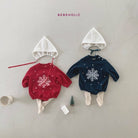 Zwei festliche Baby-Outfits liegen nebeneinander. Das linke Outfit aus der Kollektion von Himmlische Mode besteht aus einem roten Pullover mit weißem Schneeflockenmuster, cremefarbenen Strumpfhosen und einem Star Bonnet Set von Bebe Holic. Das rechte Outfit besteht aus einem marineblauen Pullover mit weißem Schneeflockenmuster, cremefarbenen Strumpfhosen und einer weißen Haube.